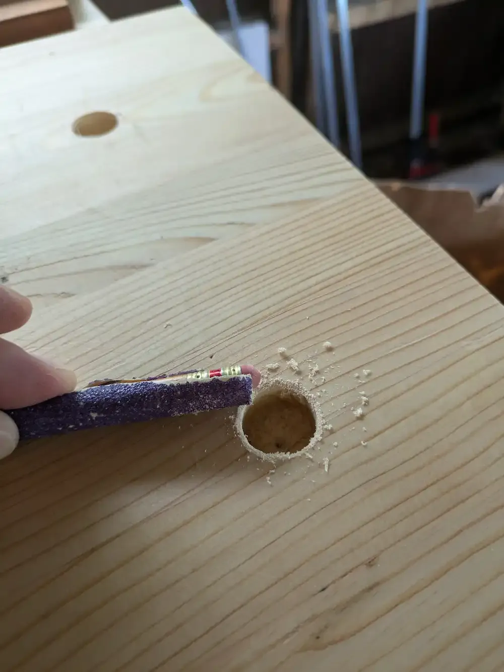 Using sandpaper to round over the edges of a hole before fully boring